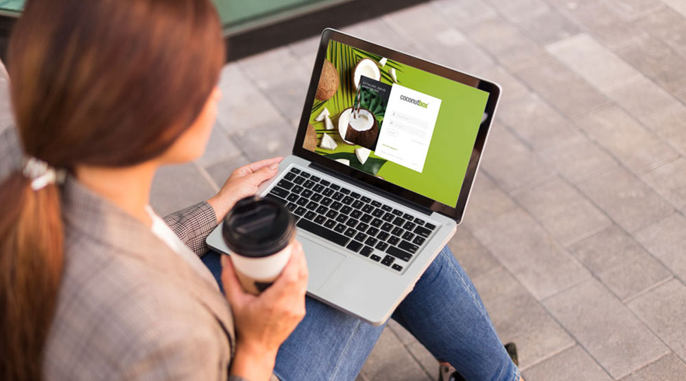 Frau mit coconutbox auf Laptop