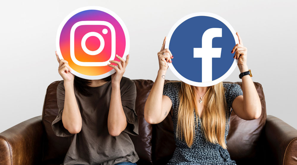 zwei Personen halten Schild mit Instagram- bzw. Facebook-Logo vor Gesicht